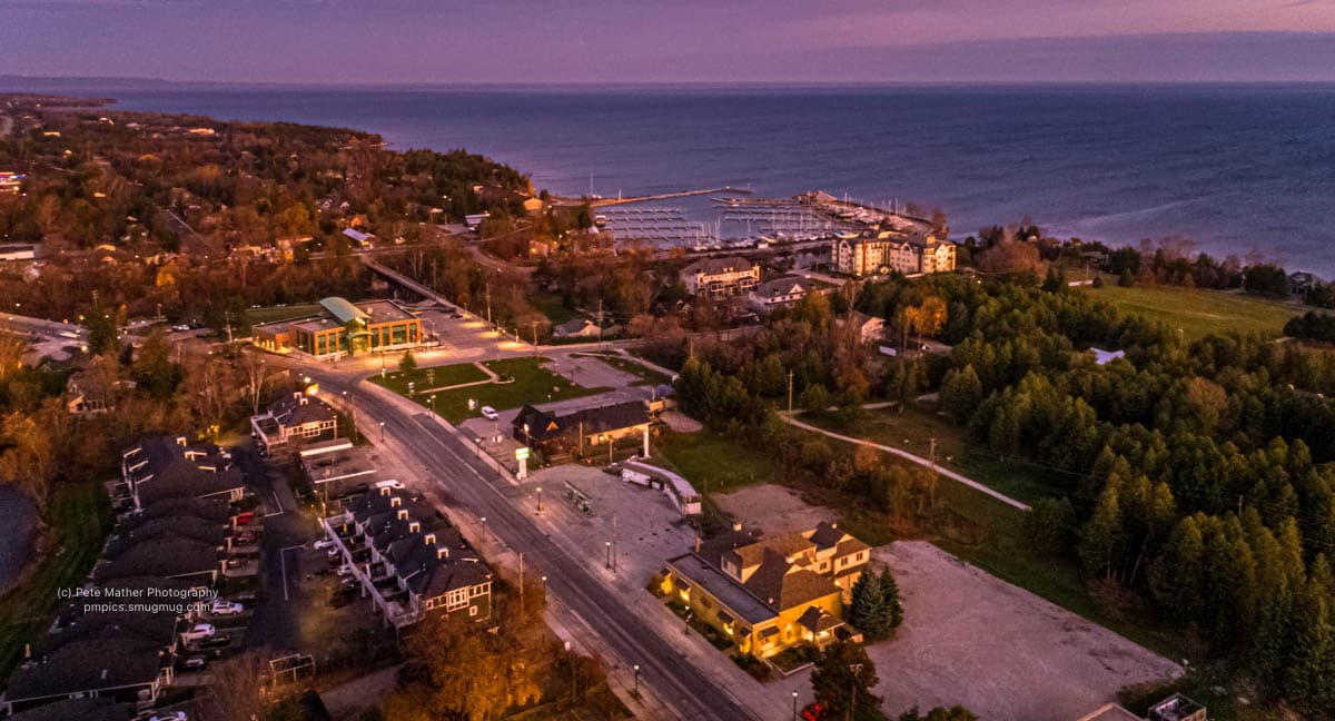 Aerial view of a town, road and harbour at dusk